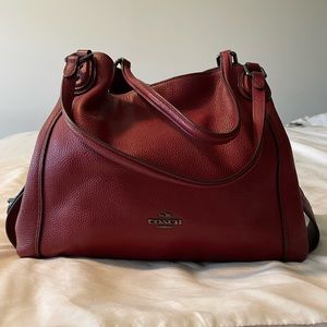 Coach shoulder bag with 3 compartments, and a center lock zipper.
